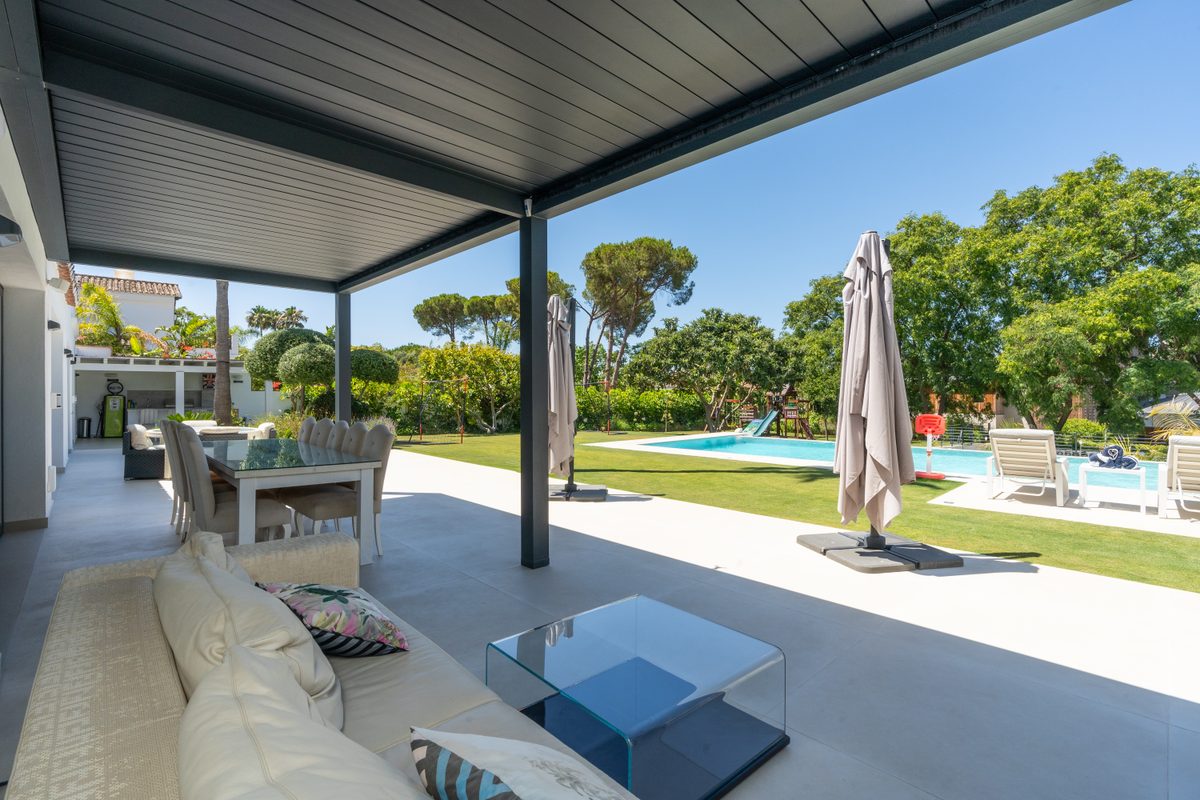 Covered terrace lounge opening onto the garden