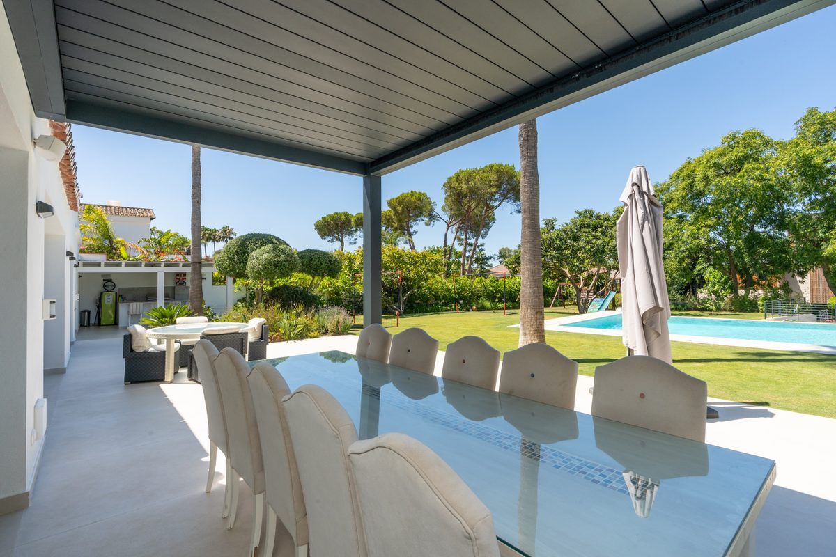 Covered outdoor dining area beside the garden
