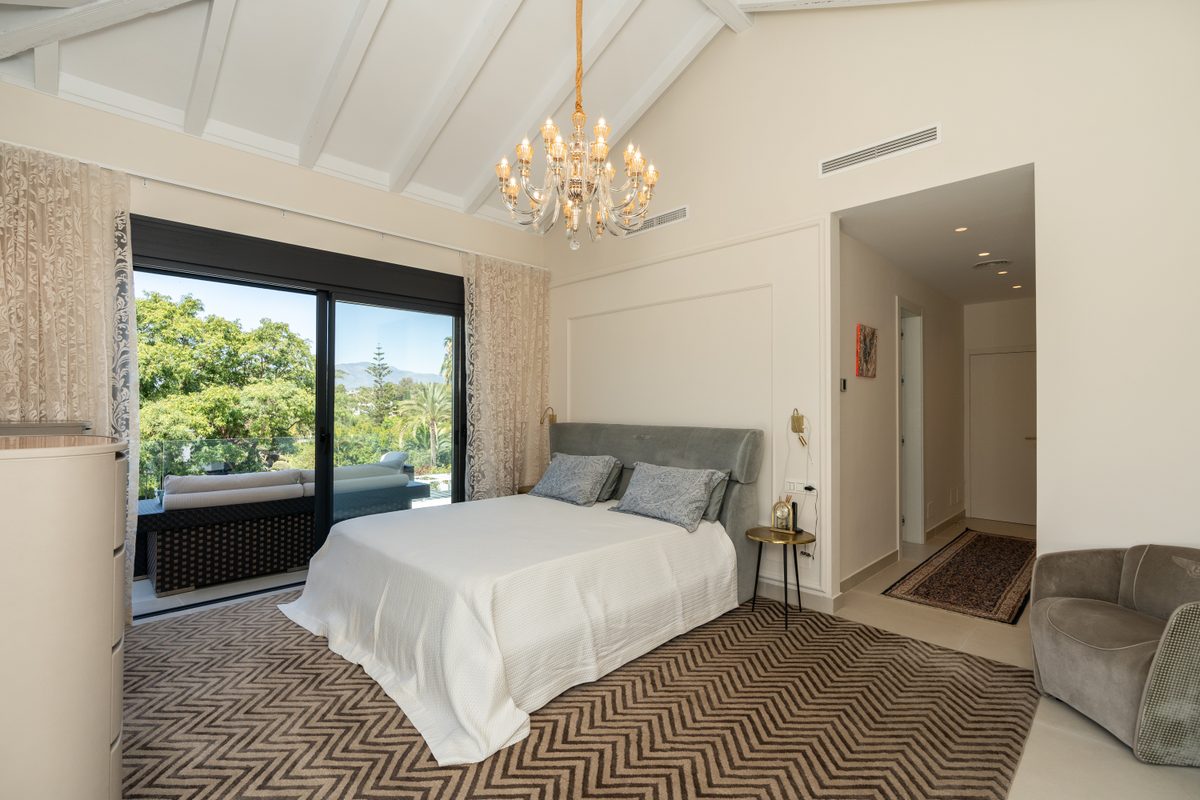 Bright bedroom with vaulted ceiling and garden view