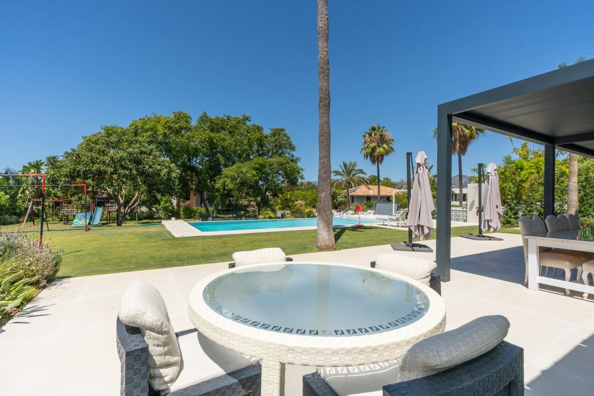 Outdoor jacuzzi with the pool and garden behind