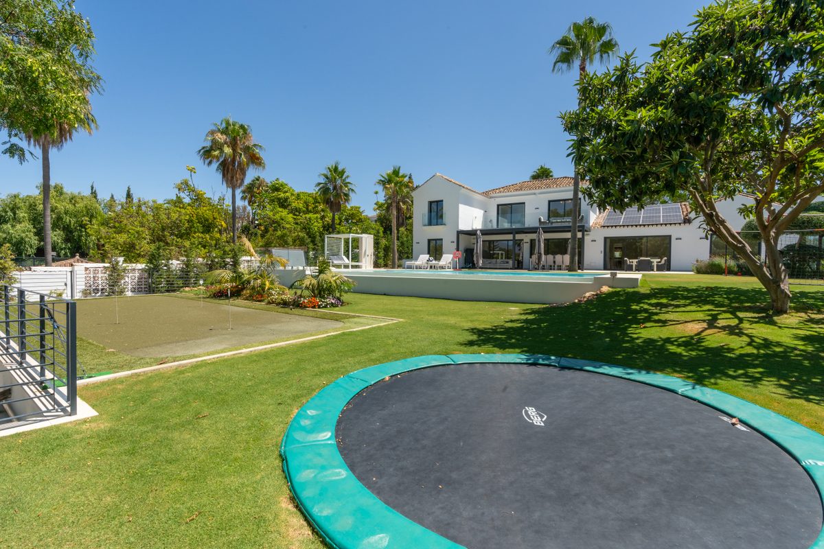 Garden with trampoline, pool and villa